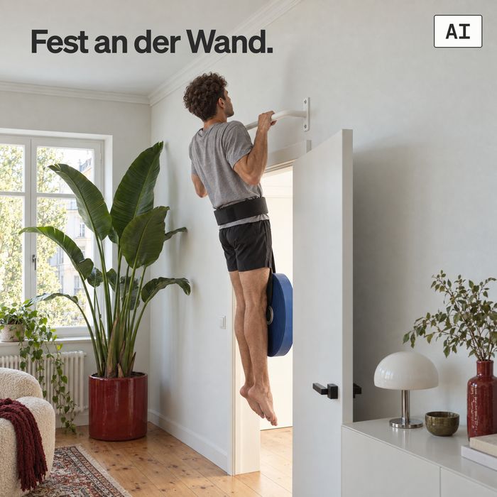 Ein Mann macht einen Klimmzug mit Zusatzgewicht an der KS1 aus weißen Stahl in einem hellen Altbau-Wohnzimmer (KI-generiertes Bild)