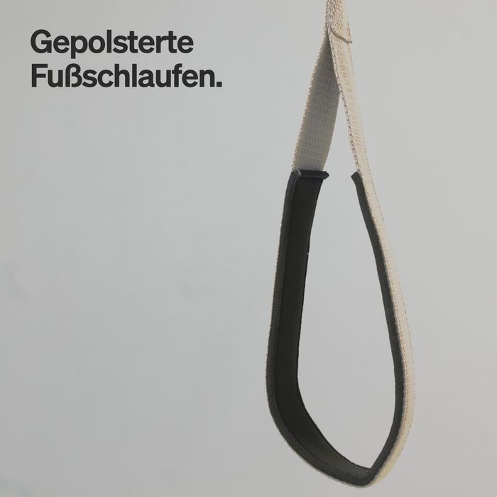 Nahaufnahme einer gepolsterten Fußschlaufe aus sandfarbenem Gurt mit schwarzem Polster