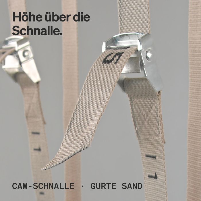 Nahaufnahme der Cam-Schnalle an einem sandfarbenen Gurt mit Zahlenmarkierung