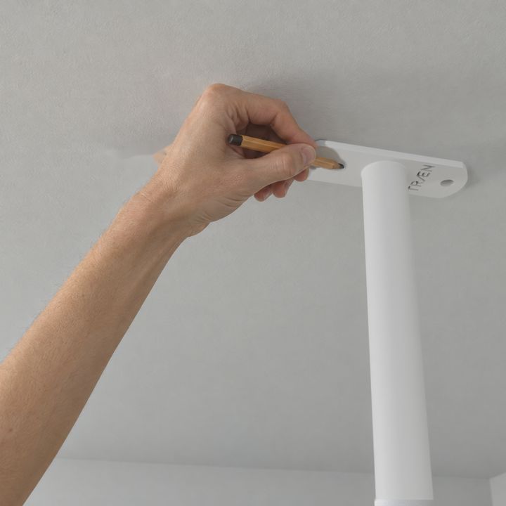 Die Stange wird an die Decke gehalten; ein Stift zeichnet die Löcher an der Deckenplatte an.