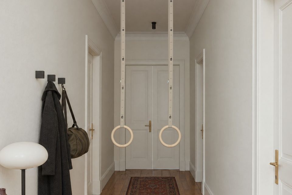 Turnringe hängen in einem hellen Flur von der Decke.