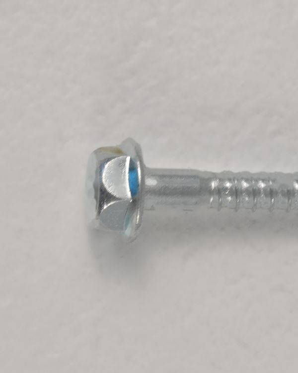 Kopf der Schraube aus dem Lieferumfang, schräg von vorn: Sechskant mit Torx.